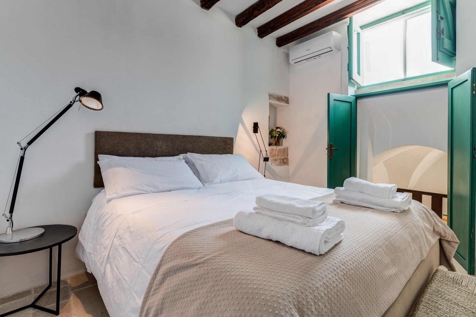Camera da letto con biancheria bianca della Masseria Bel Cortile