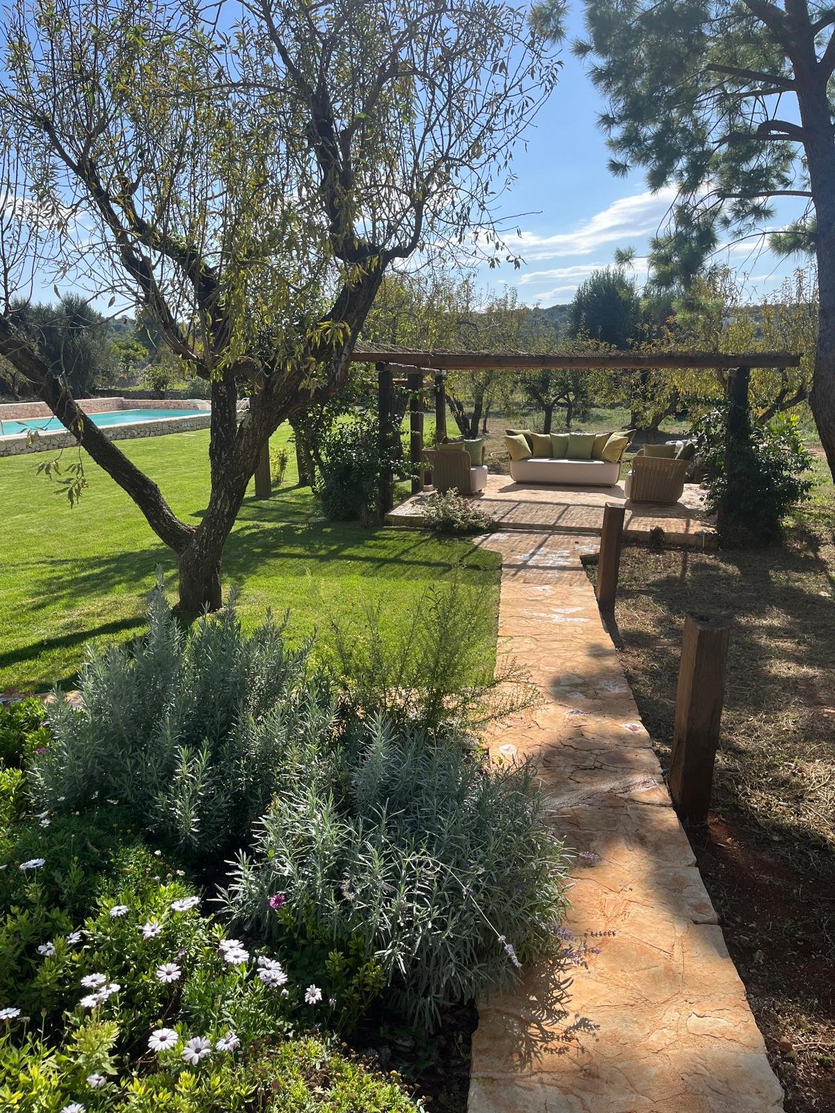 Vialetto in pietra tra lavanda e fiori nel giardino della masseria