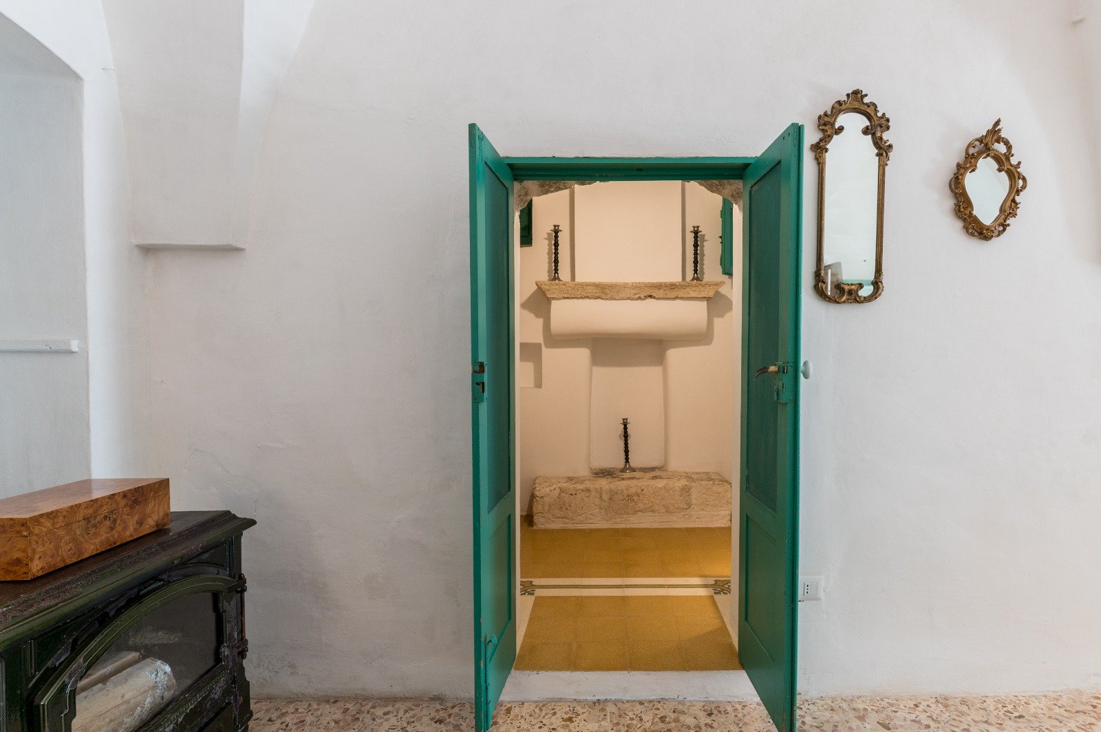 Interno luminoso con porta verde e specchio della masseria