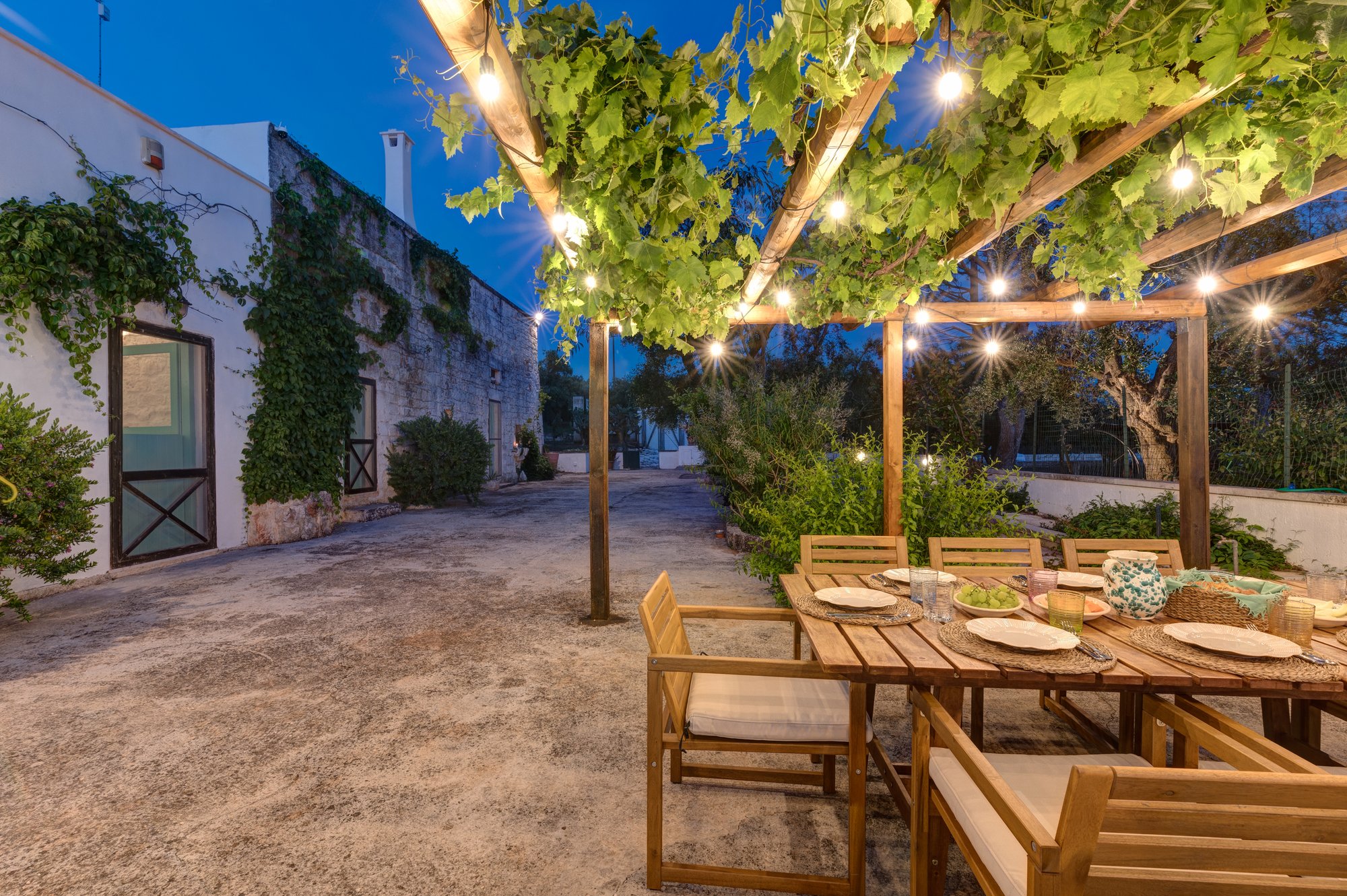 Pergolato e corte illuminati di sera alla Masseria Bel Cortile, Ostuni